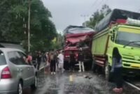 Truk merah menabrak truk hijau yang sedang parkir hingga mengalami kerusakan parah