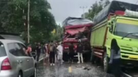 Truk merah menabrak truk hijau yang sedang parkir hingga mengalami kerusakan parah
