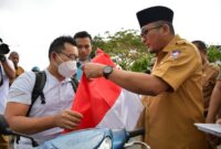 Wali Kota Padang Hendri Septa saat membagikan bendera merah putih kepada pengendara yang melintas di depan Kantor Balaikota, Selasa (2/8). Foto: Dinas Kominfo Kota Padang
