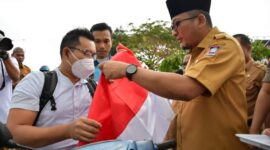 Wali Kota Padang Hendri Septa saat membagikan bendera merah putih kepada pengendara yang melintas di depan Kantor Balaikota, Selasa (2/8). Foto: Dinas Kominfo Kota Padang