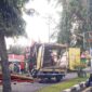 Satu unit mobil box berwarna kuning usai bagian atas mobil menabrak pohon.