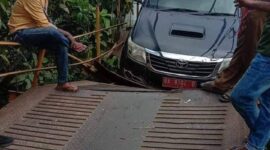 Mobil berplat merah yang tersangkut di jembatan yang menghubungkan dua kecamatan di Pesisir Selatan 