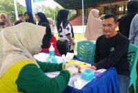 Petugas medis Dinas Kesehatan Kabupaten Pesisir Selatan memeriksa darah peserta tes kebugaran jasmani di GOR H. Ilyas Yakub Painan, Kamis (16/10/2025)
