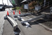 Sebuah kendaraan terhenti di tepi jalan yang runtuh di kota Tohoku di Prefektur Aomori, pada tanggal 9 Desember 2025, menyusul gempa berkekuatan 7,5 skala Richter di lepas pantai utara Jepang (JIJI Press/AFP)