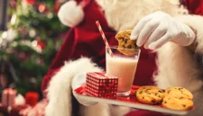 
<p>Kue dan susu untuk Santa dan wortel untuk rusa kutub tertinggal di atas meja di depan api yang menyala dan pohon Natal yang menyala.

